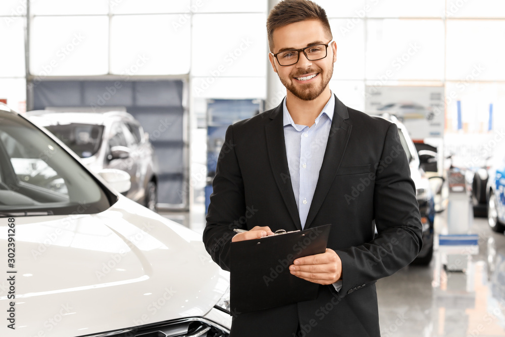 Salesman near car in modern salon