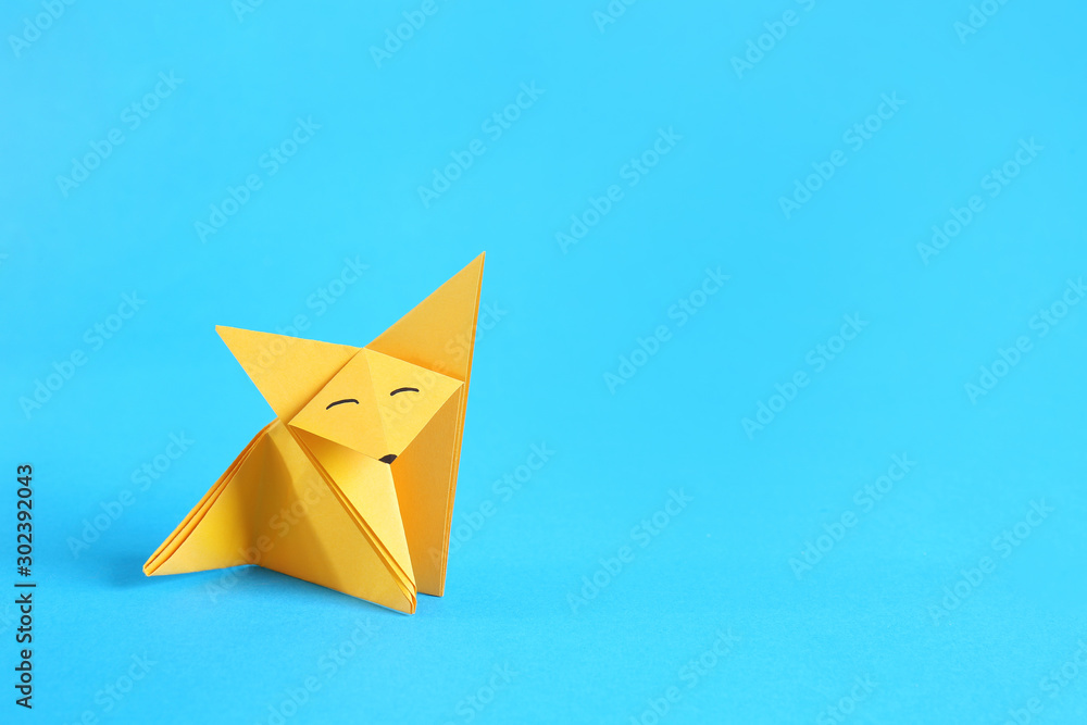 Origami fox on color background