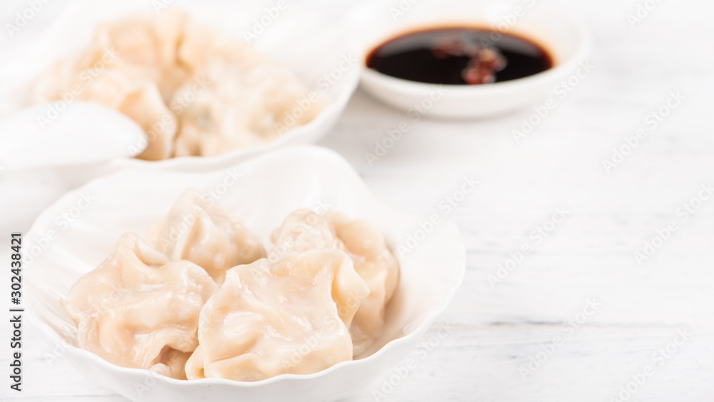 Fresh, delicious boiled pork, shrimp gyoza dumplings on white background with soy sauce and chopstic