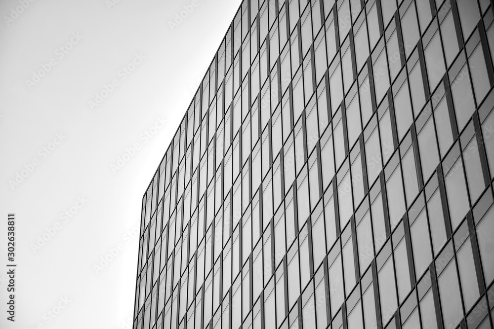 Curtain wall made of toned glass and steel constructions under sky. A fragment of a building. Black 