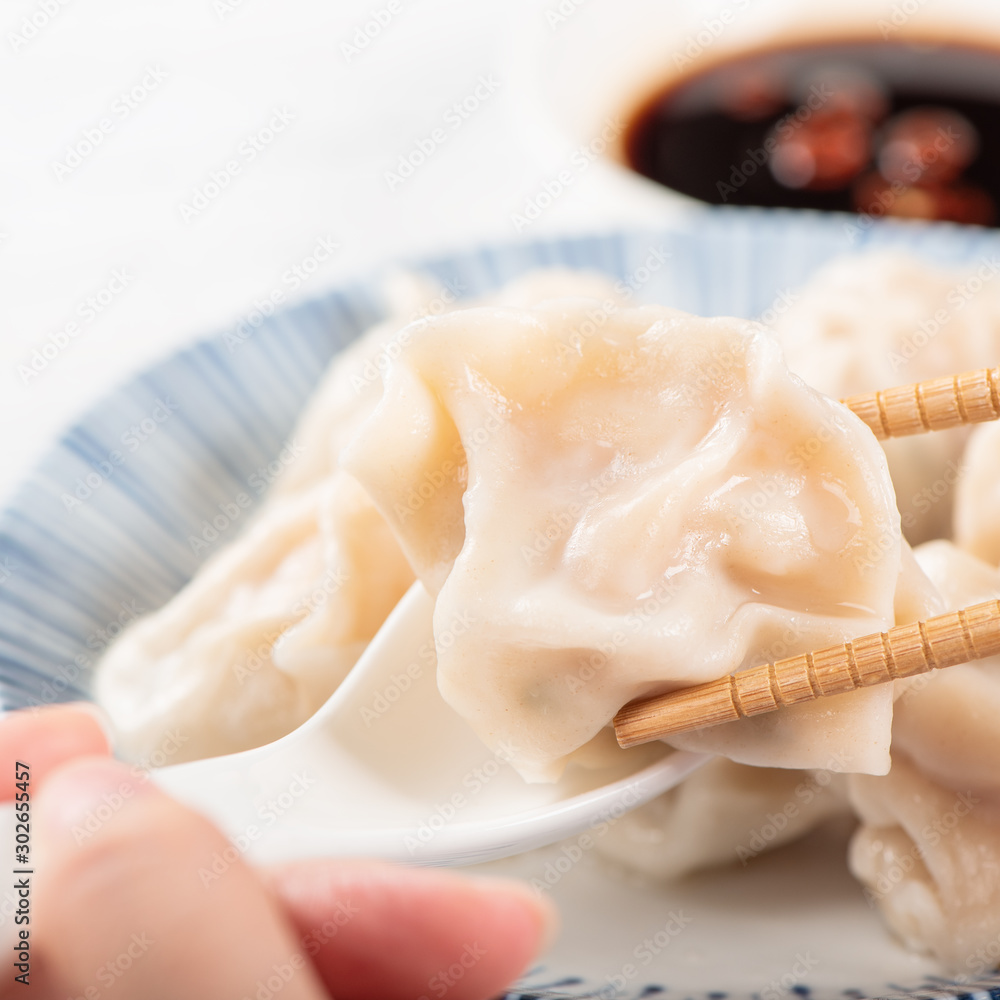 Fresh, delicious boiled pork, shrimp gyoza dumplings on white background with soy sauce and chopstic