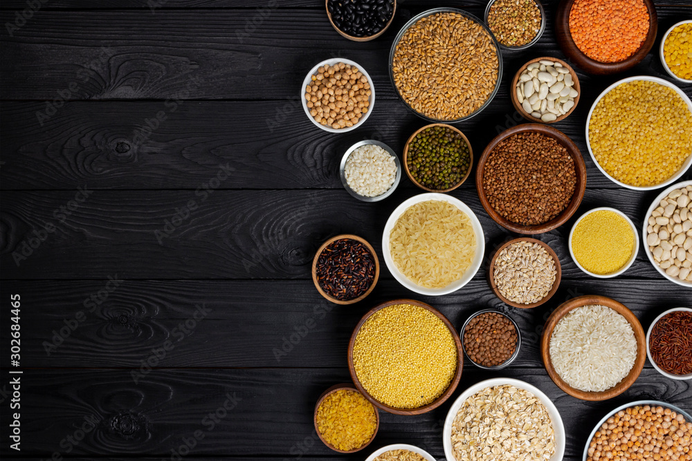 Cereals, grains, seeds and groats black wooden background