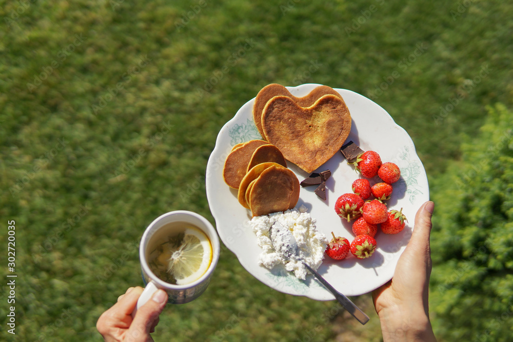 Dessert plate with pancakes, strawberry, greek yogurt and tea with lemon