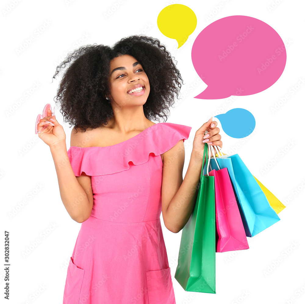 Beautiful African-American woman with shopping bags on white background