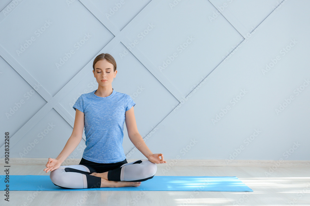 Young woman practicing yoga at home