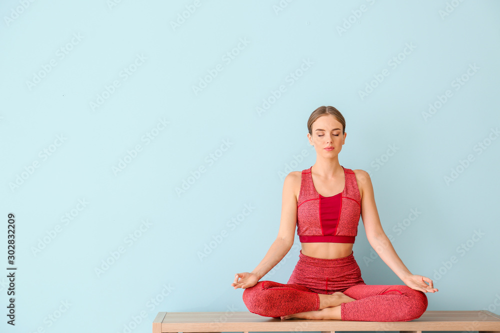 Young woman practicing yoga on color background