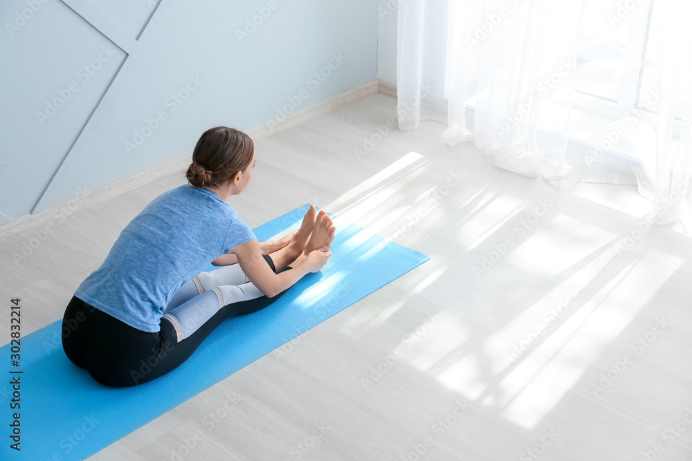 Young woman practicing yoga at home