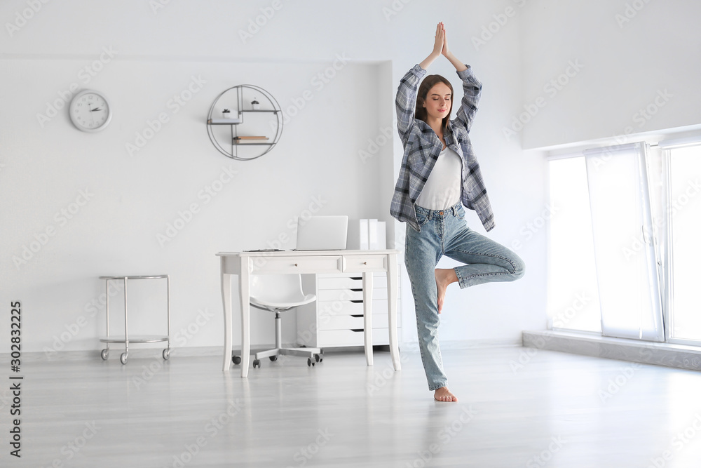 Young woman practicing yoga at home