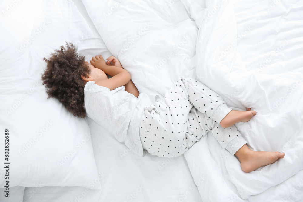 Little African-American girl sleeping in bed