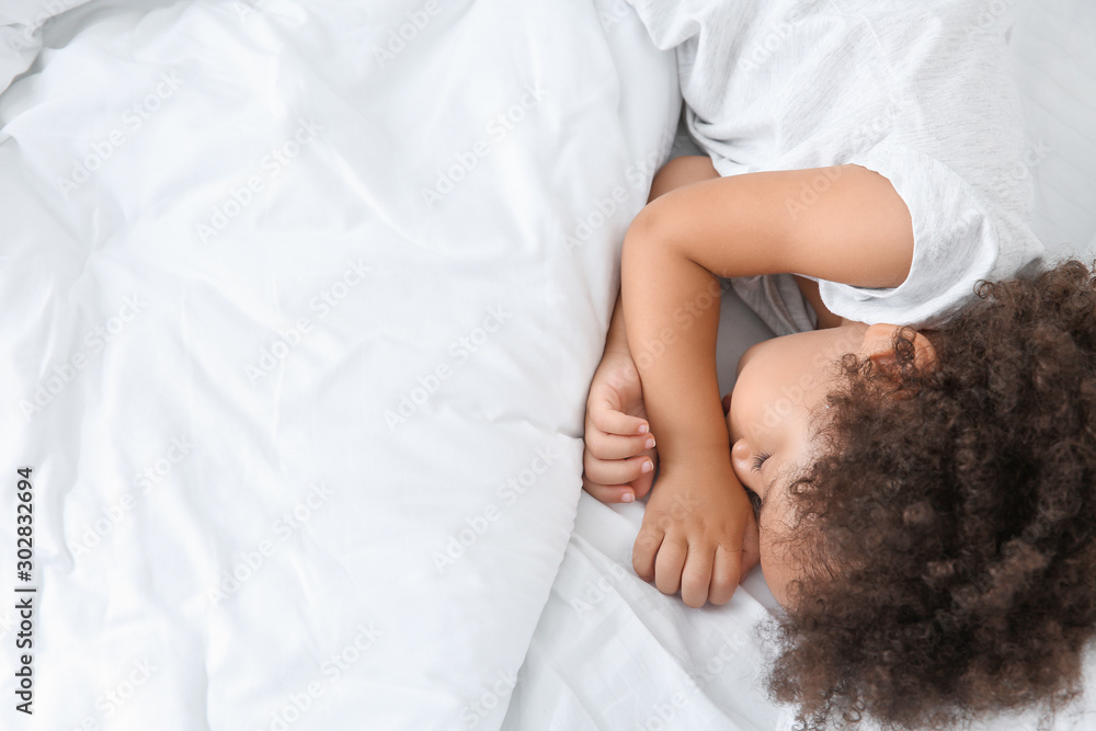 Little African-American girl sleeping in bed