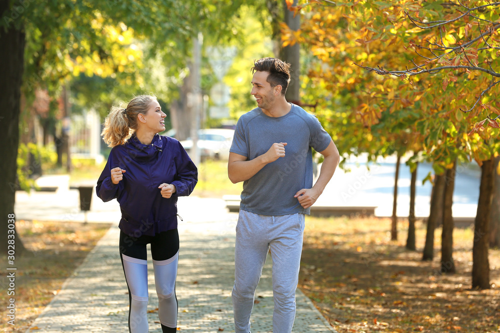 Sporty young couple running in park