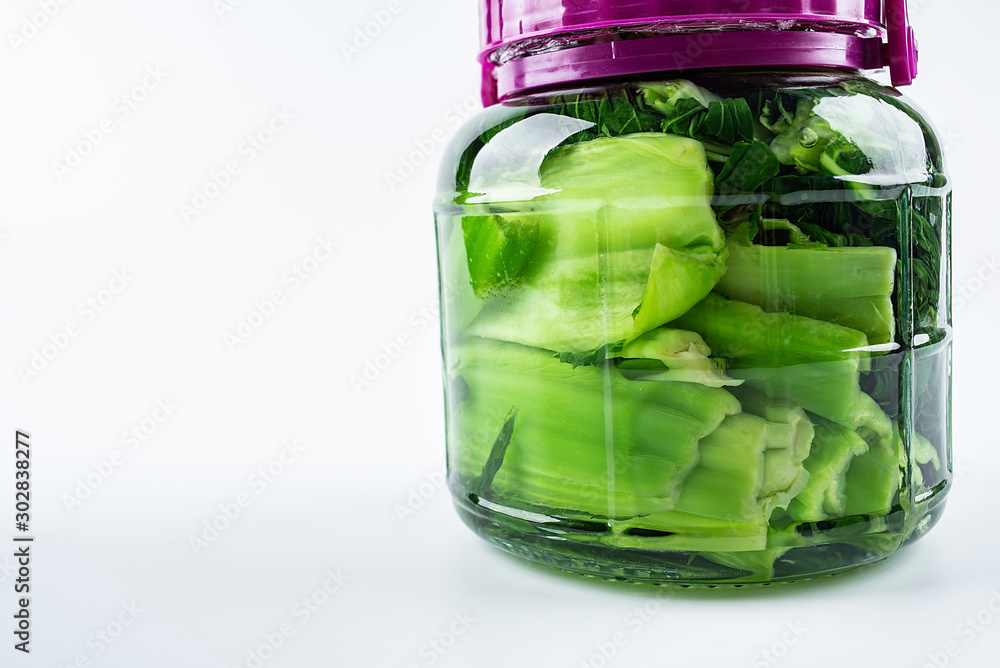 Freshly made one glass jar of green sour mustard on white background