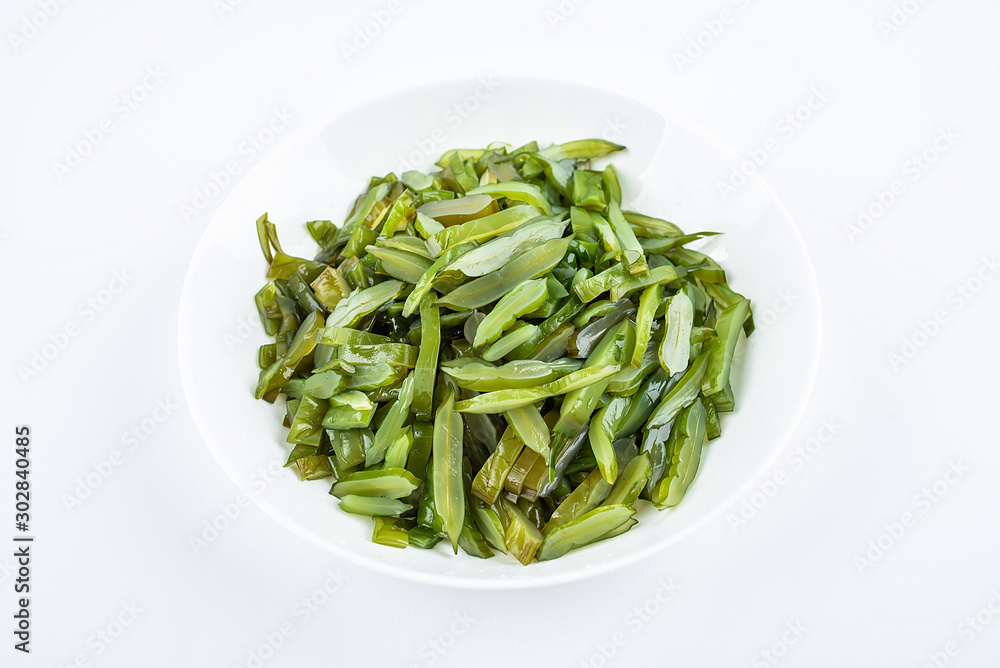 Freshly cut sea cabbage on a saucer on a white background