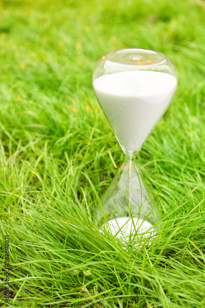 Crystal hourglass on grass outdoors