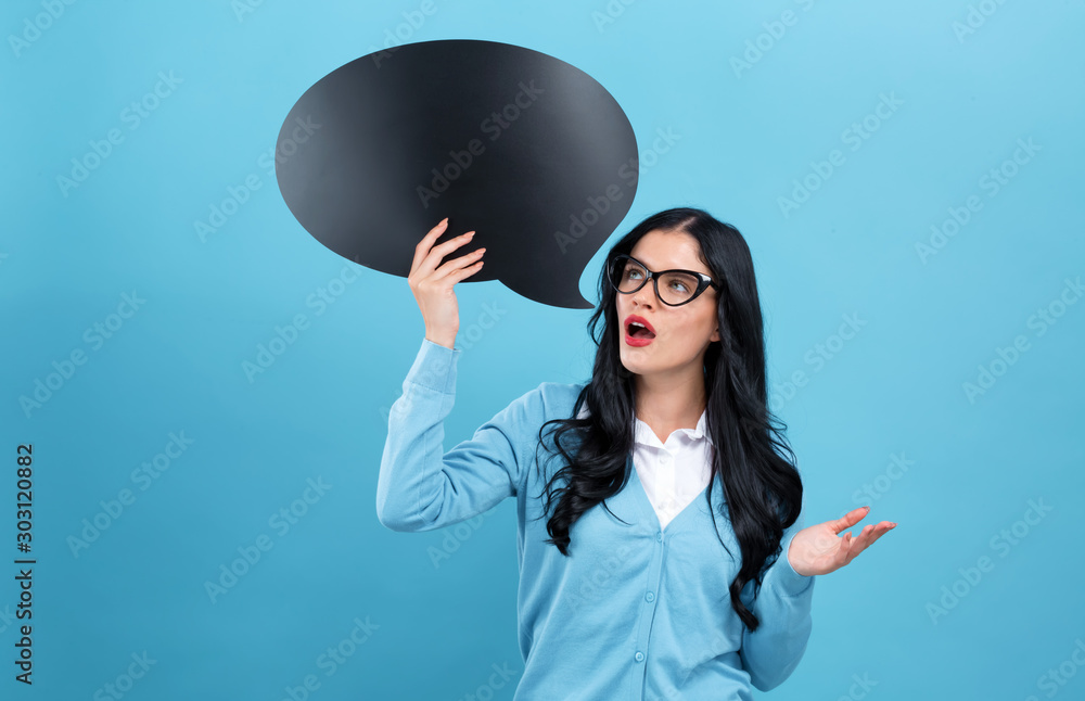 Young woman holding a speech bubble on a blue background