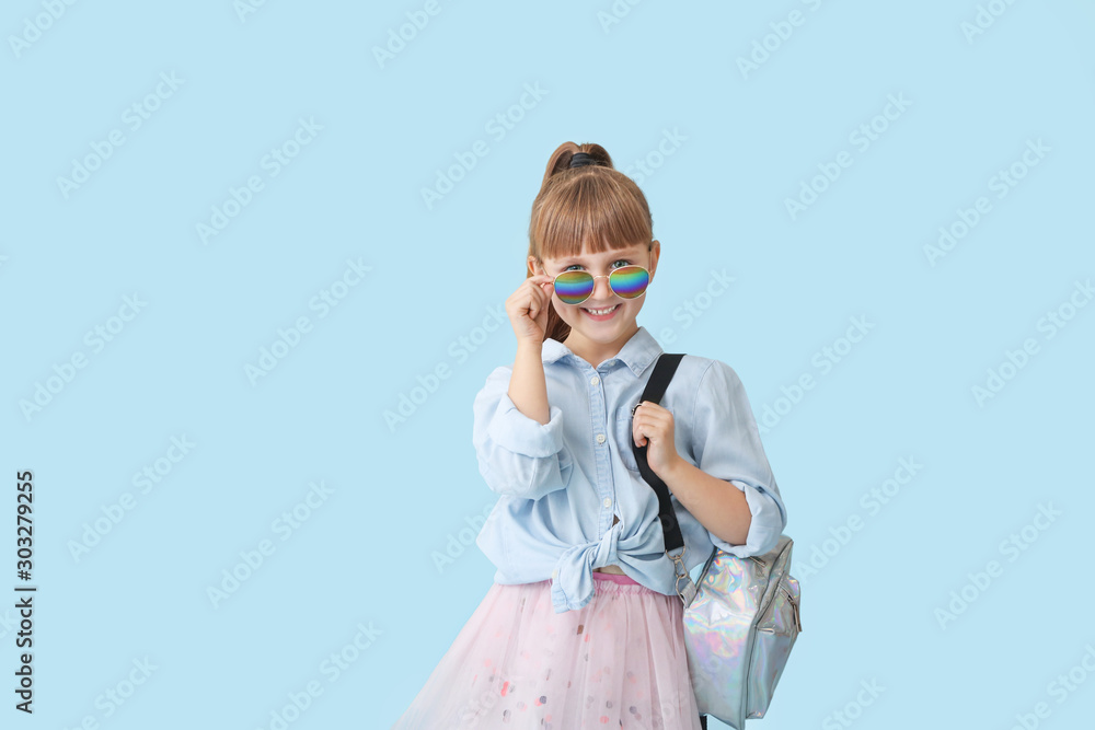 Fashionable little girl on color background