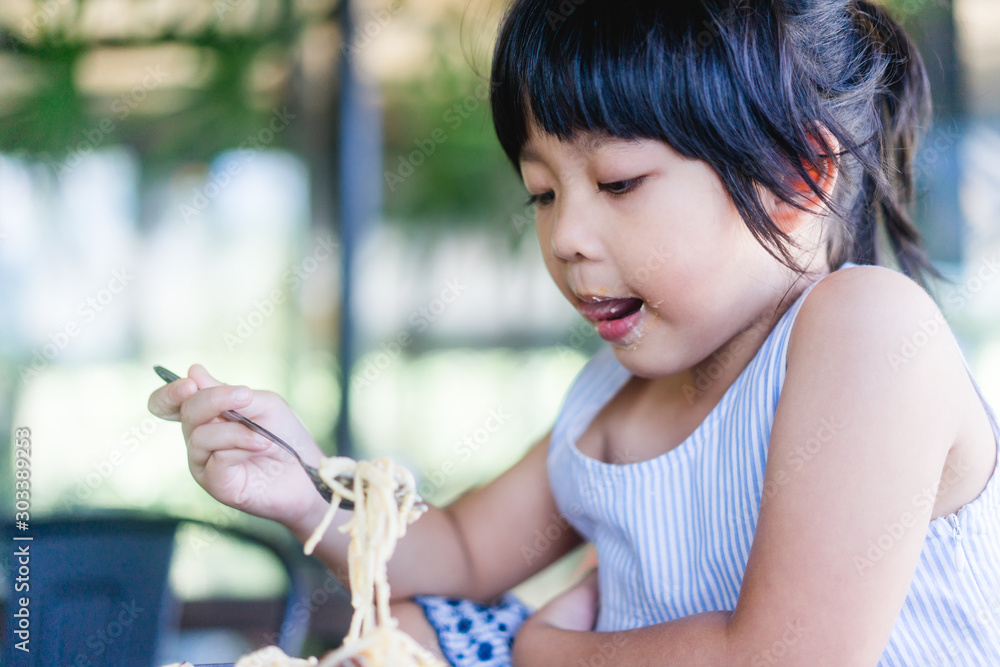 Hungry face and enjoy eating concept.Little asian girl enjoy eating with spaghetti carbonara with ch