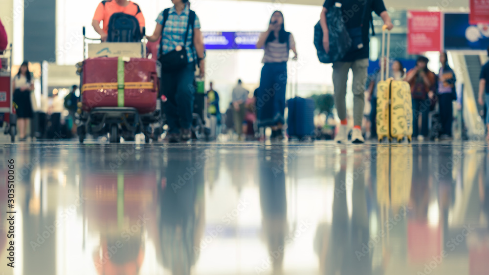 Scene of traveller with luggage reflection on floor in airport during busy hour