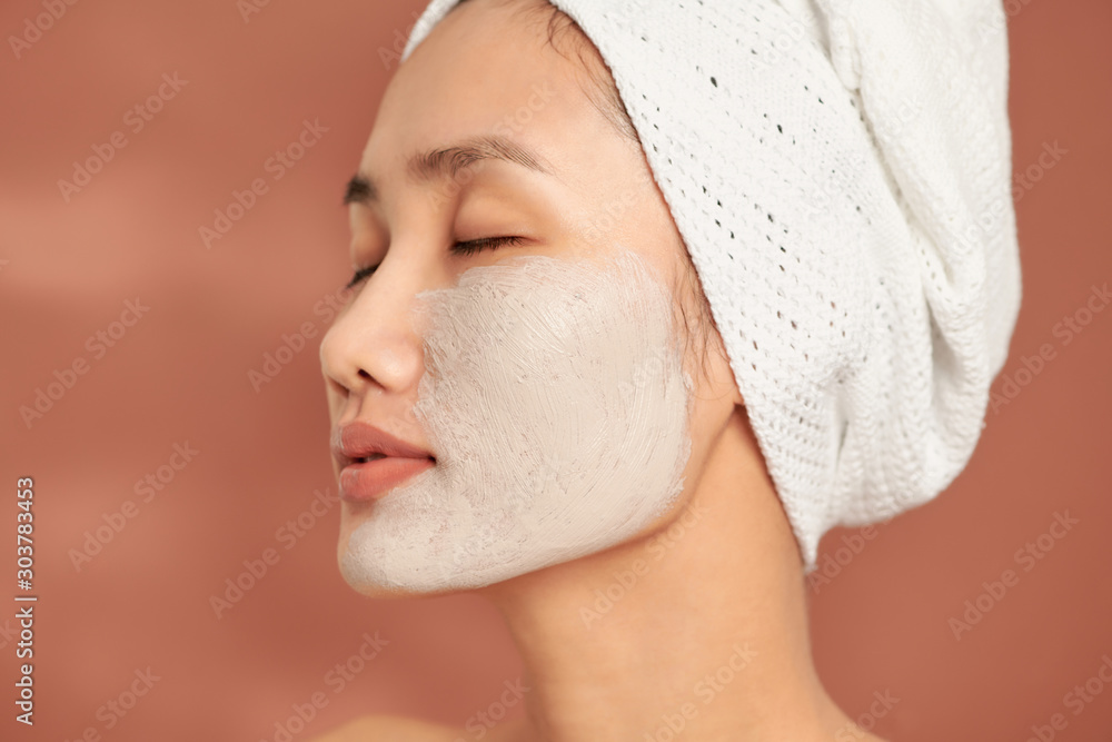 Young beautiful woman with clay face mask. Spa treatment, self care and healthy skin