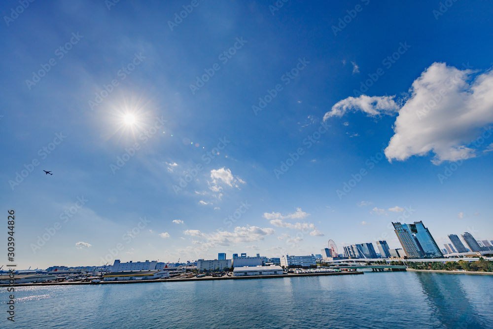 水辺に建つ都会のビル群と青空