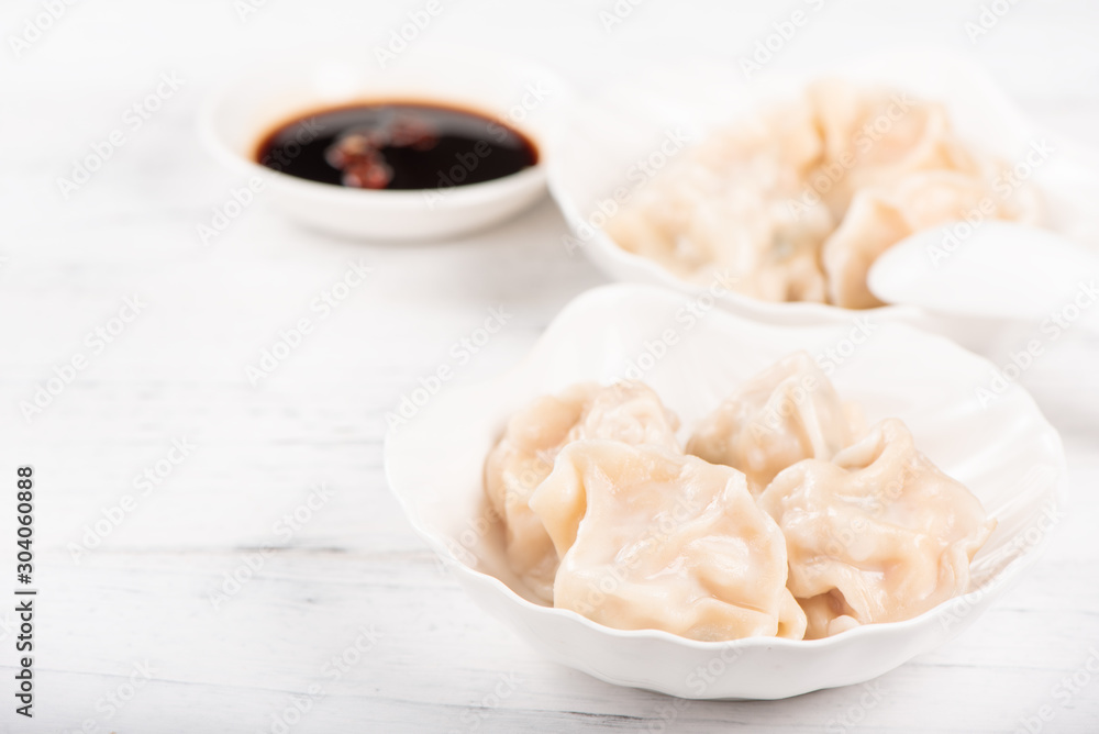 Fresh, delicious boiled pork, shrimp gyoza dumplings on white background with soy sauce and chopstic