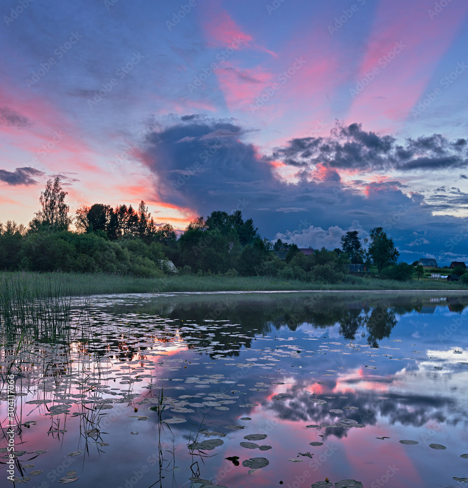  Village summer landscape a lake at sunset.