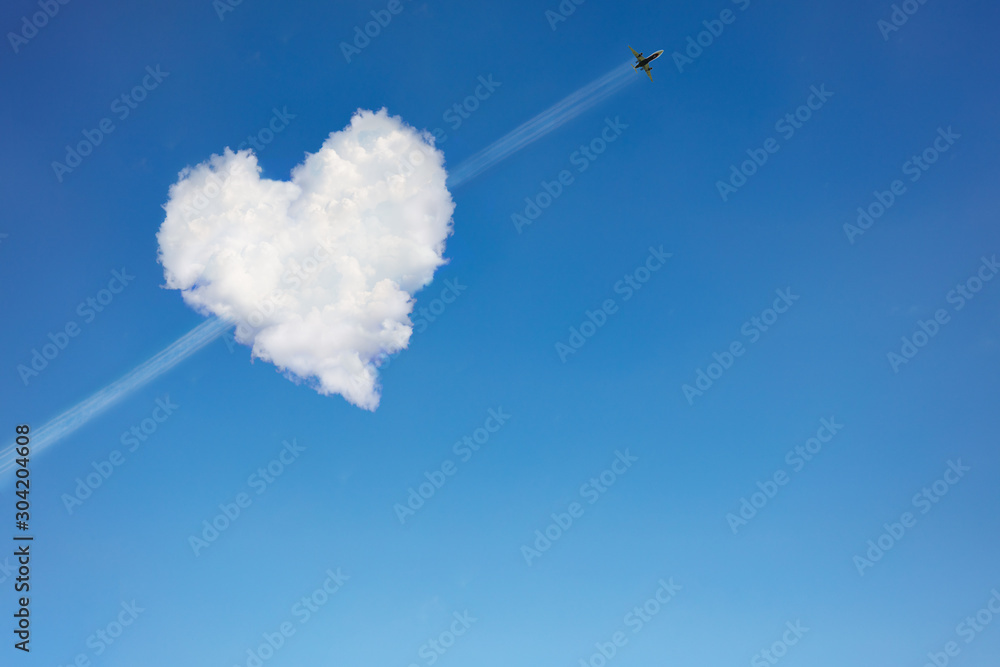 Airplane passing through the heart shaped cloud