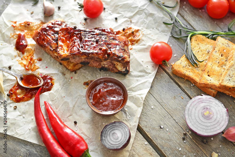 Tasty grilled meat with barbecue sauce, vegetables and spices on table