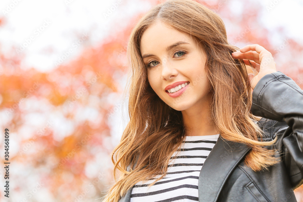 Portrait of stylish young woman in autumn park