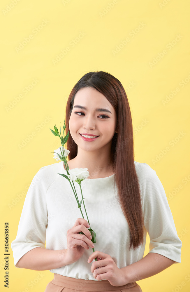 一位手持鲜花的迷人年轻女子的特写肖像