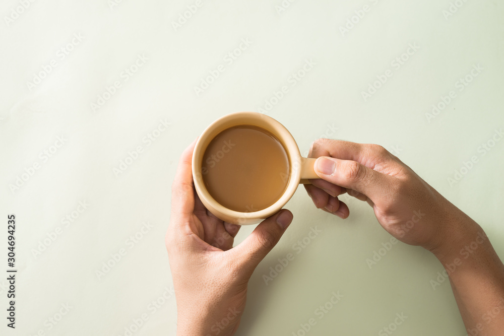 Hands holding cups of coffee on color background