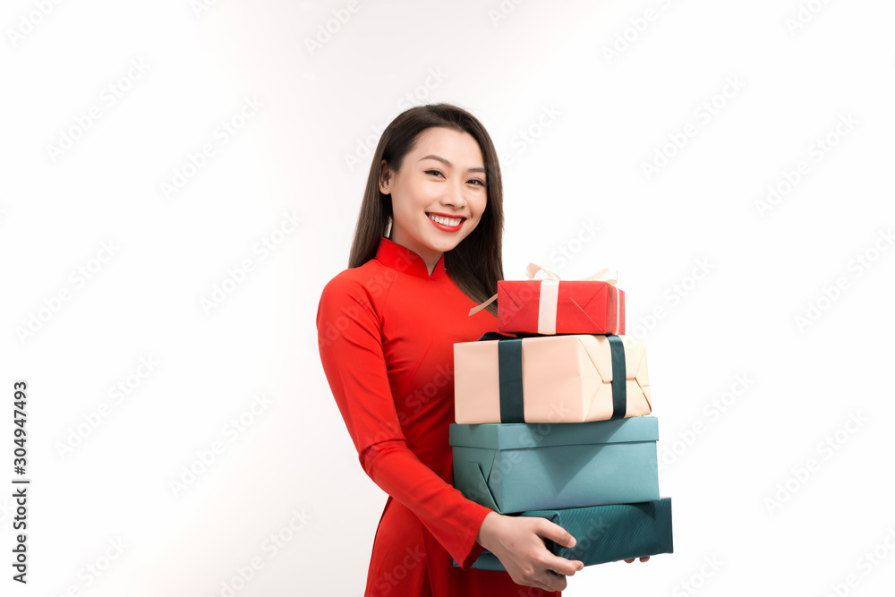 Portrait of an Asian girl in a traditional Vietnamese dress, ao dai, a good smile, holding gift box