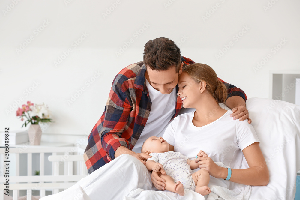 Young family with newborn baby in maternity hospital