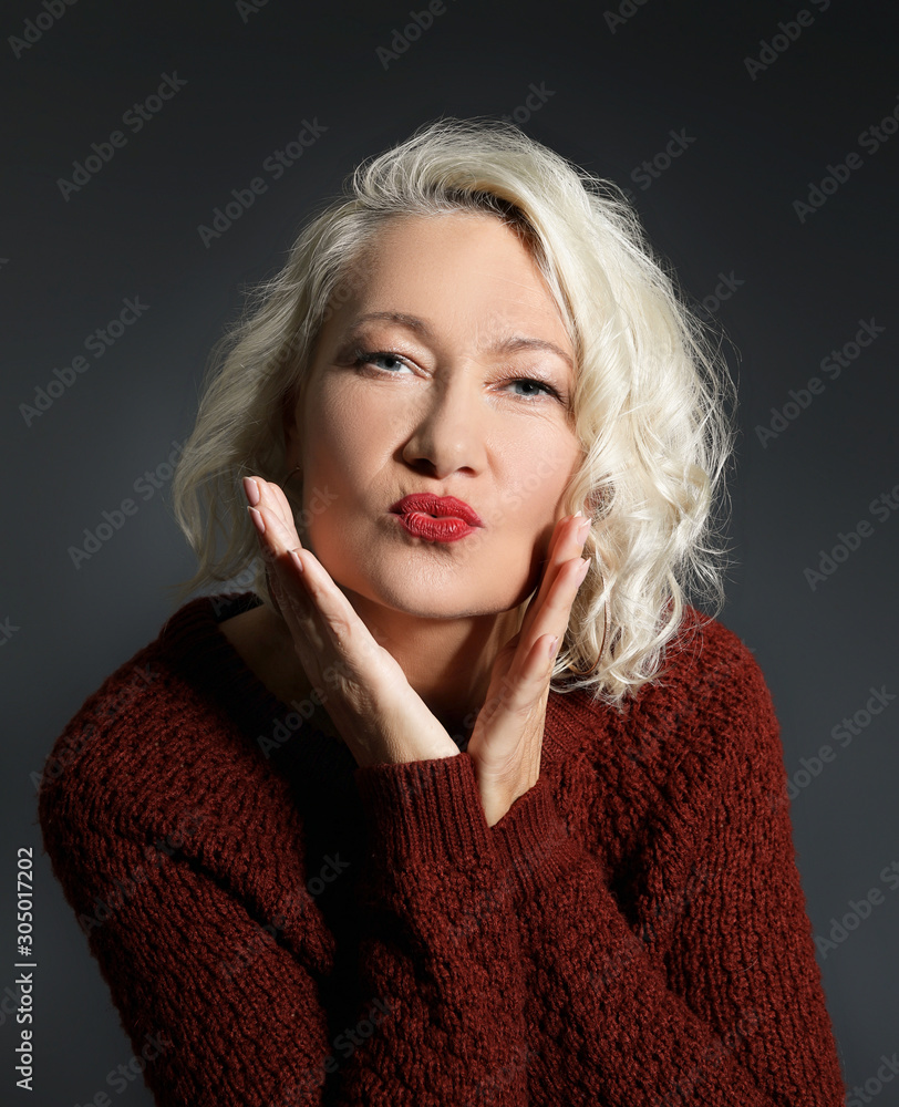 Portrait of stylish mature woman on dark background