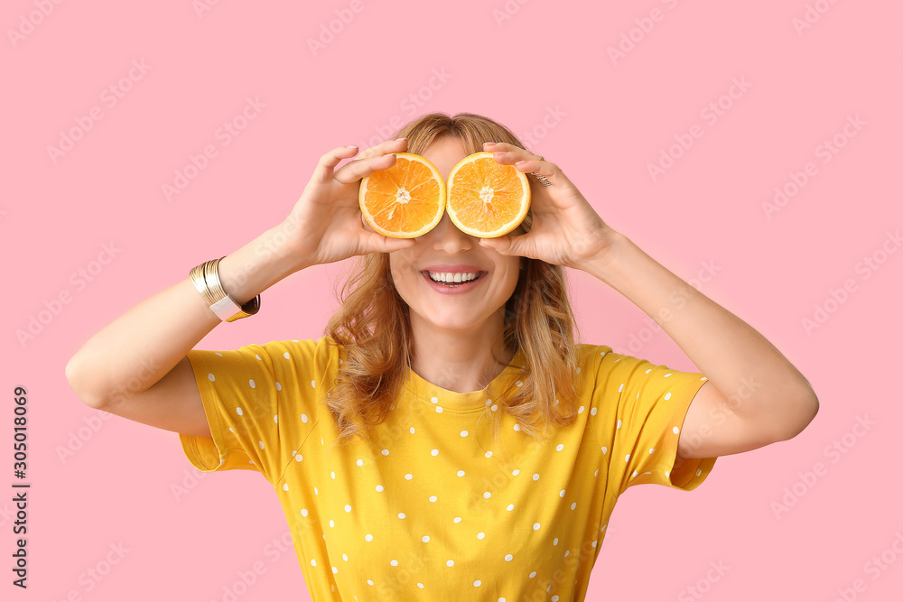 Funny mature woman with cut orange on color background