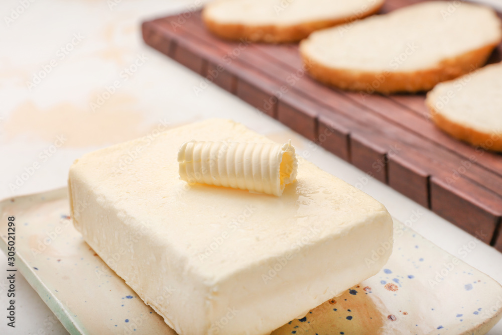 Tasty fresh butter and bread slices on table