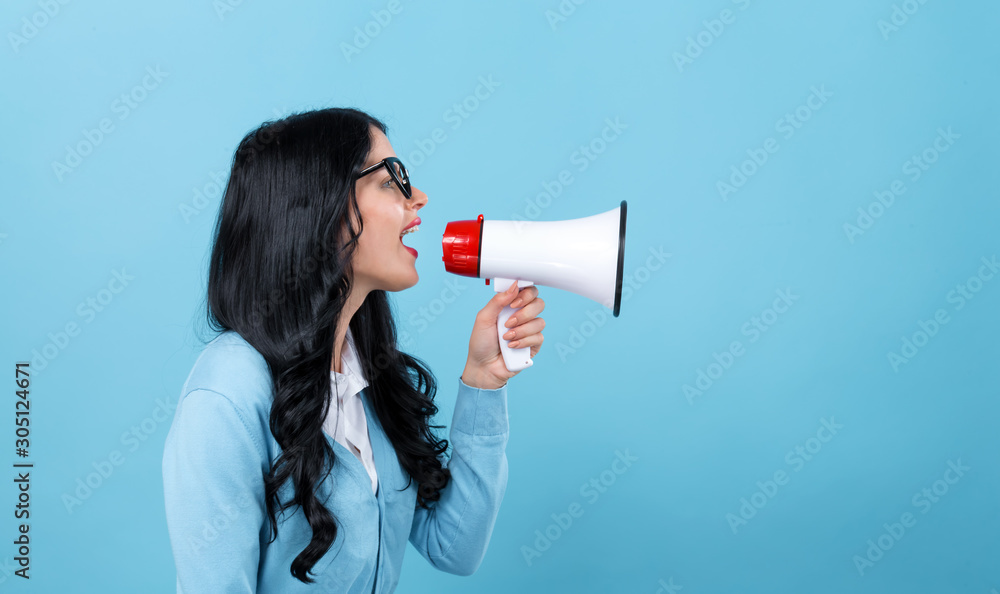 Young woman with a megaphone on a blue background