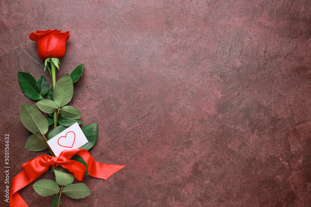 Beautiful rose, ribbon and card on color background. Valentines Day celebration