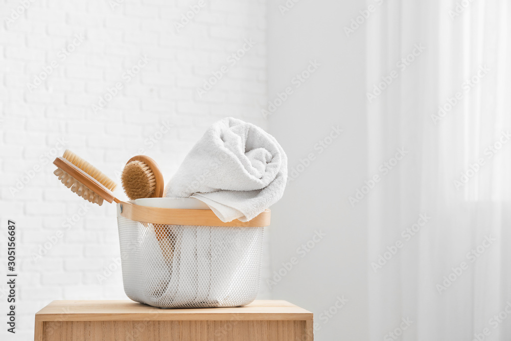 Basket with clean towels and brushes on table