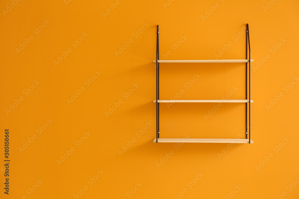 Empty shelves hanging on color wall