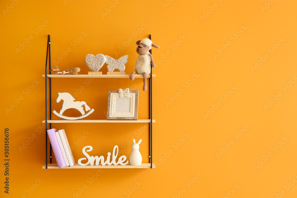 Shelves with decor hanging on color wall