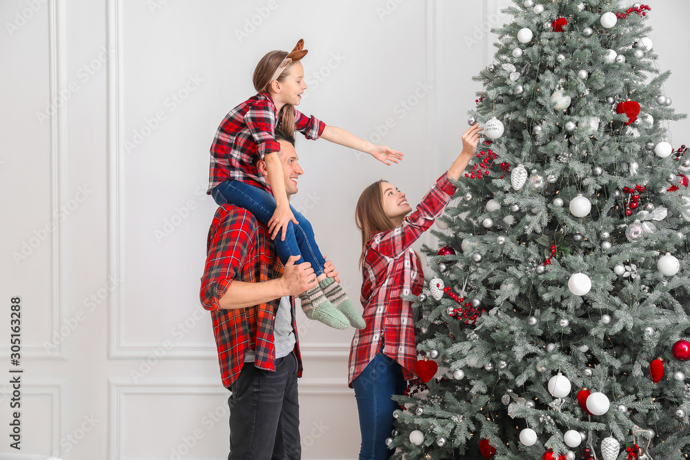 Happy family decorating Christmas tree at home