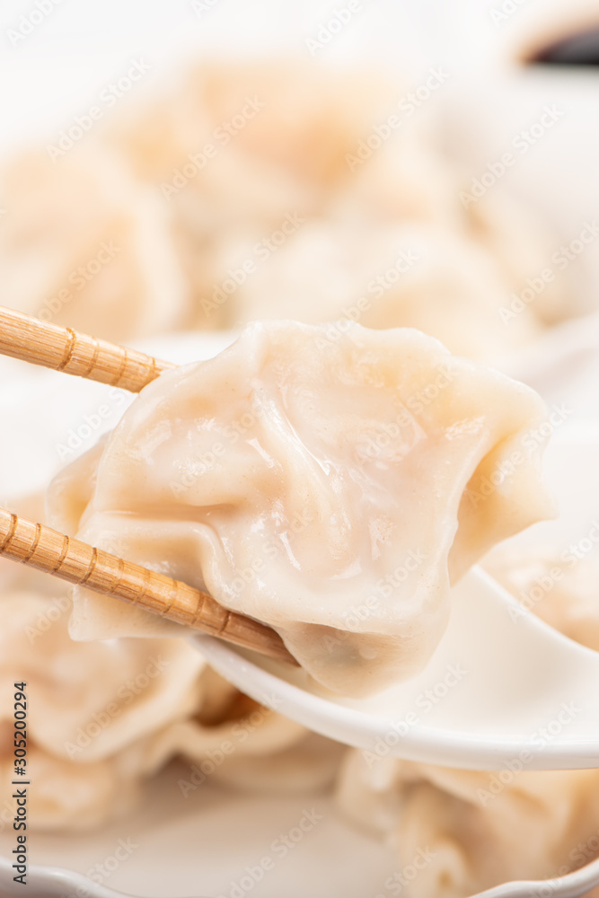 Fresh, delicious boiled pork, shrimp gyoza dumplings on white background with soy sauce and chopstic