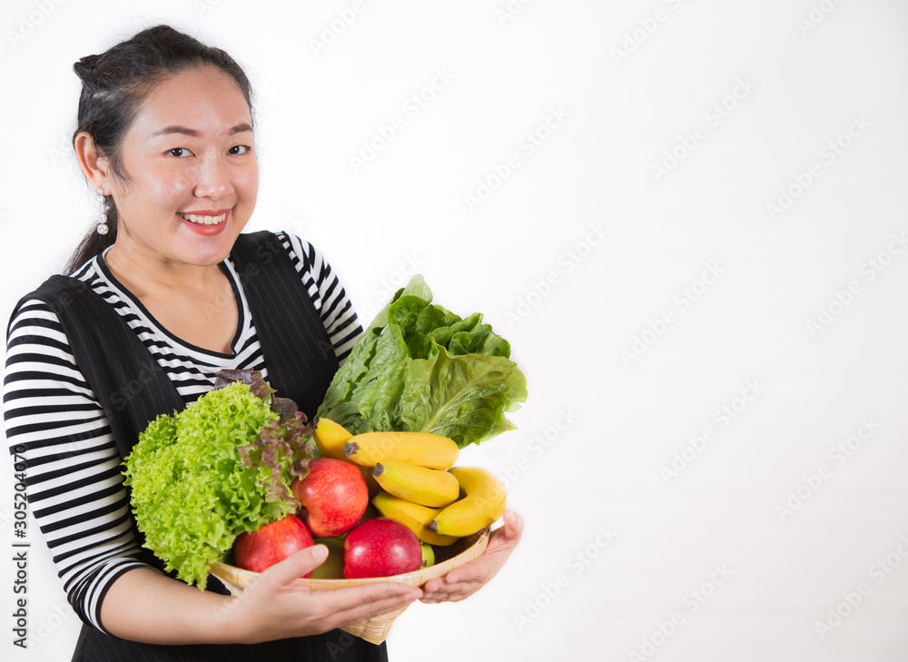 The image of a beautiful Asian woman holding healthy fruits and vegetables for diet in the white bac