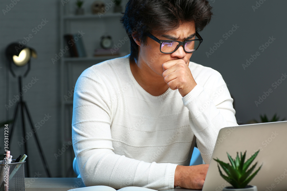 Asian programmer working late in evening