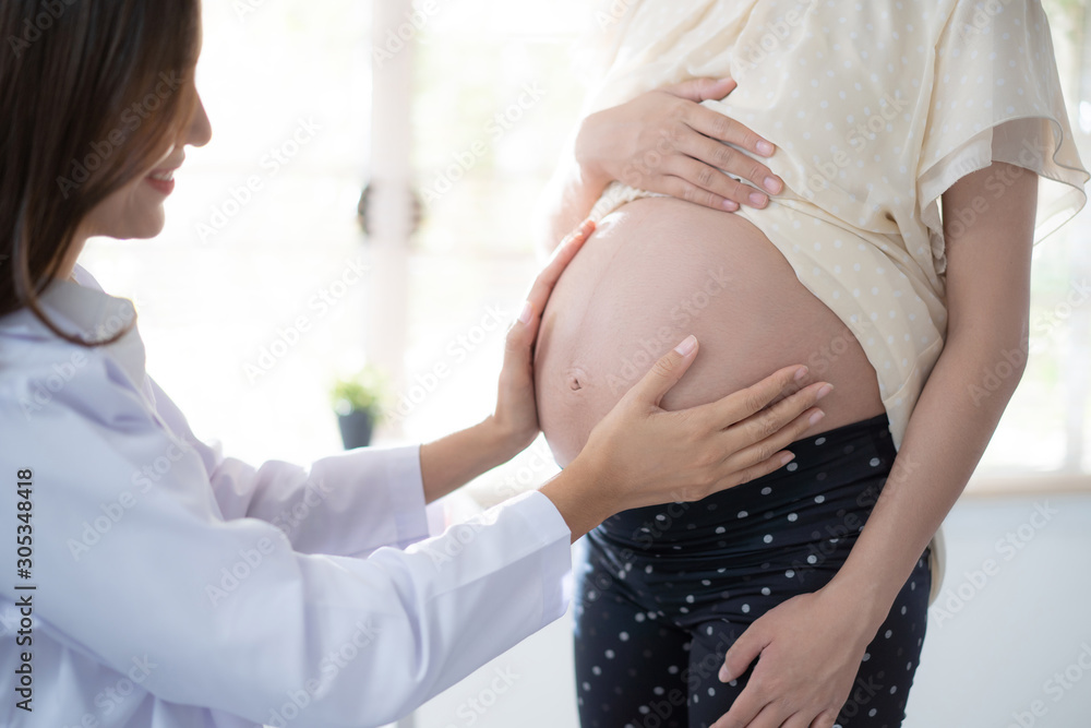 Asian doctor is examining the pregnant woman