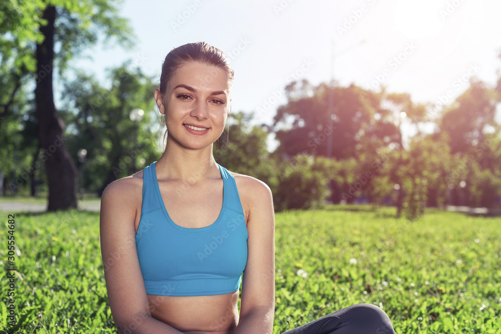 美丽的微笑女孩穿着运动服在公园放松