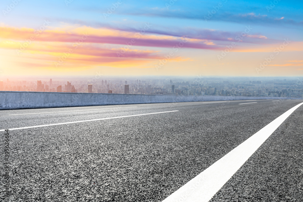 Shanghai city skyline and empty asphalt road scenery at sunset.