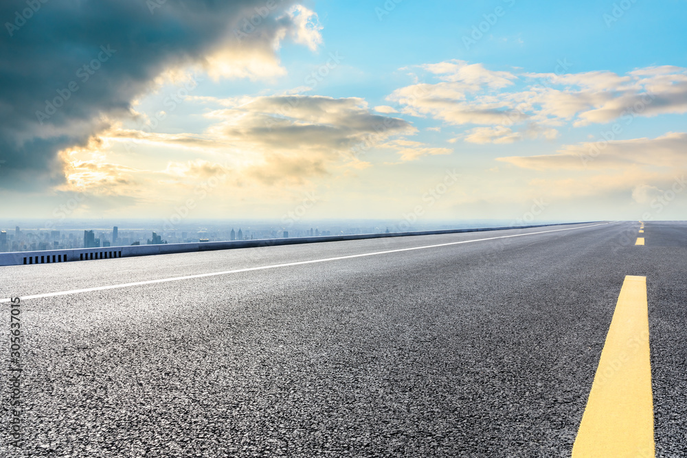 Shanghai city skyline and empty asphalt road scenery at sunset.