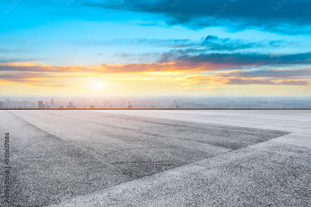 Asphalt race track ground and modern city skyline in Shanghai at sunset.